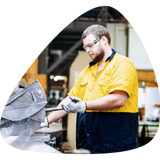 Blue collar worker in high vis uniform working in a factory